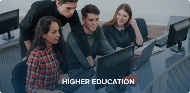 Four students collaborating at computers in a new university computer lab, with text "higher education" overlayed.