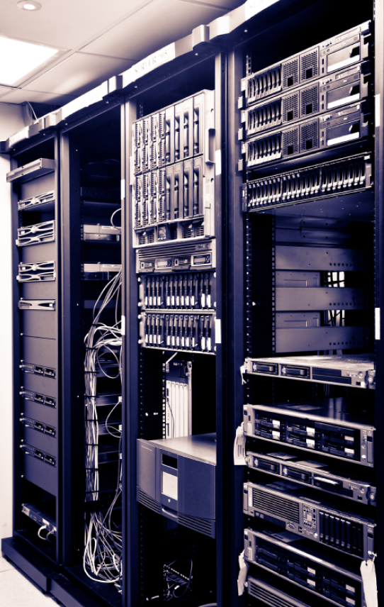 Open server racks with government IT solutions equipment and cables in a dimly lit server room, showcasing technology infrastructure.