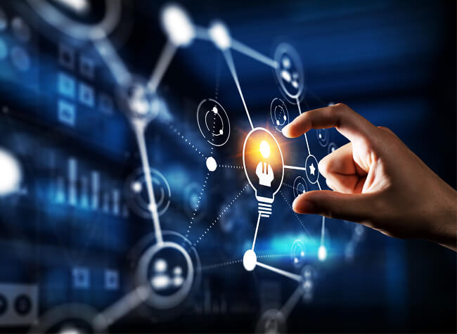 A hand interacts with a digital interface, touching a lightbulb icon among various network and technology-related symbols, signifying corporate collaboration and innovation.