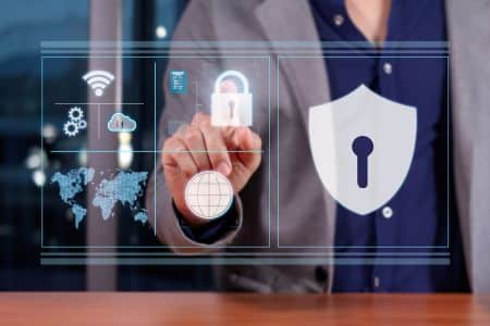 A person in business attire points at a virtual screen displaying cybersecurity icons, including a lock, shield, globe, and world map—highlighting the importance of cybersecurity in Federal IT Modernization.