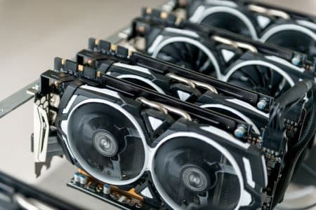 A row of multiple low-power GPUs installed on a mining rig, showing the cooling fans and electronic components.