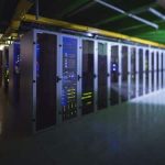 A row of server racks with illuminated equipment and cables in a modern data center, optimized for virtualization and AI training.